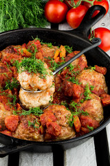 Homemade turkey meatballs. Cutlets in the pan. Tomato sauce. Rustic style.