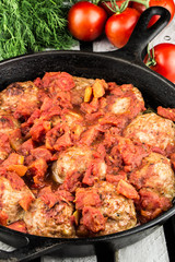 Homemade turkey meatballs. Cutlets in the pan. Tomato sauce. Rustic style.