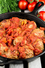 Homemade turkey meatballs. Cutlets in the pan. Tomato sauce. Rustic style.