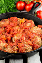 Homemade turkey meatballs. Cutlets in the pan. Tomato sauce. Rustic style.