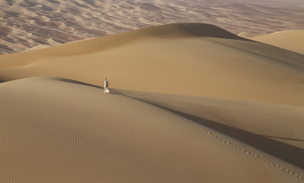 Man In Kandura In A Desert At Sunrise