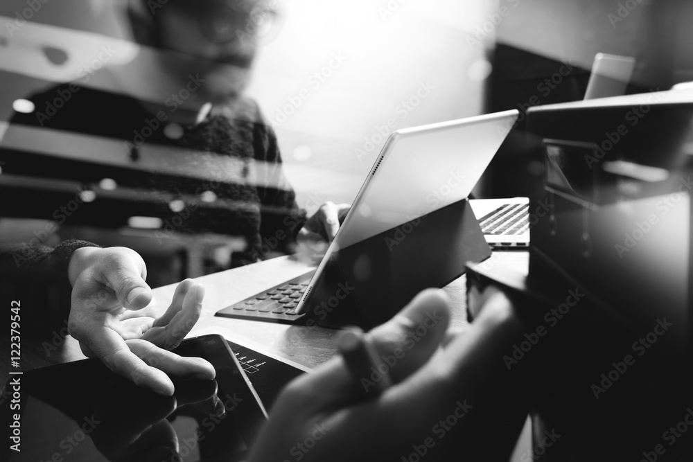 Poster Website designer working digital tablet and computer laptop with digital tablet and digital design diagram on wooden desk and compact server