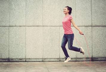 young fitness woman jumping rope outdoor