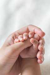 Baby hand holding finger mom. (Selected focus)