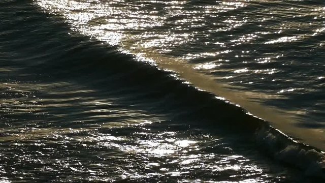 Loop of the sea waves. Backlight with patches of sunlight. Natural dawn footage. FHD
