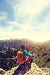 Fototapeta premium successful woman backpacker enjoy the view on mountain peak cliff