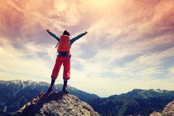 cheering young woman hiker open arms on mountain top.. - obrazy, fototapety, plakaty