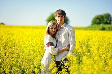 Couple on traditional dress at yellow flowers field