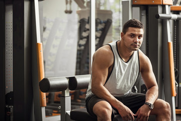 Good looking professional sportsman sitting in a gym