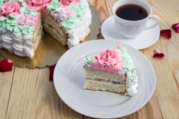 piece of sponge cake  with curd cream  and banana on  background of cake and cup of coffee