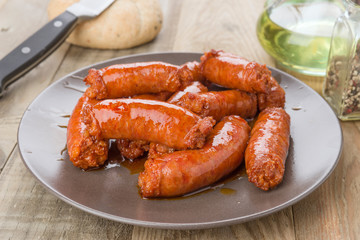 grilled sausage on brown porcelain dish on wood