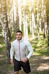 Serious confident man running in the trees