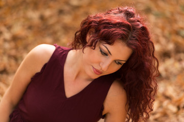 Fototapeta premium Beautiful young woman with red hair in the park