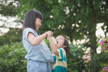 Cute Asian child eating an ice cream outdoors