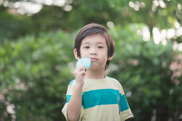 Cute Asian child eating an ice cream outdoors