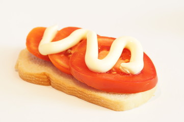 
Sandwich with tomato and mayonnaise isolated on background. Greenery.