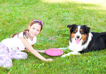 Child playing with dog outdoors
