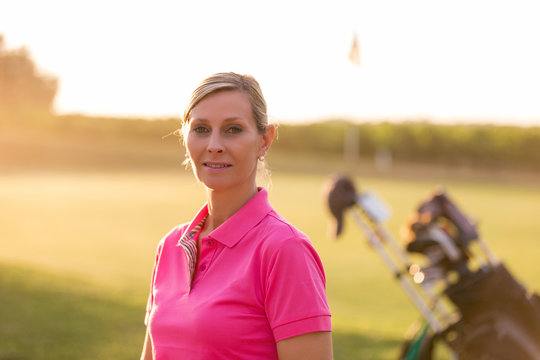 female Golfer portrait on sunset with flare