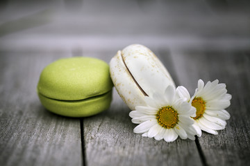Macarons with Daisy Flowers on rustic wooden Table