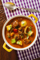 Beef stew served with cooked potatoes.