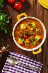 Beef stew served with cooked potatoes.