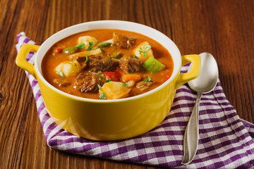 Beef stew served with cooked potatoes.