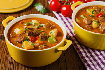 Beef stew served with cooked potatoes.