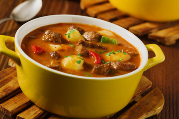 Beef stew served with cooked potatoes.