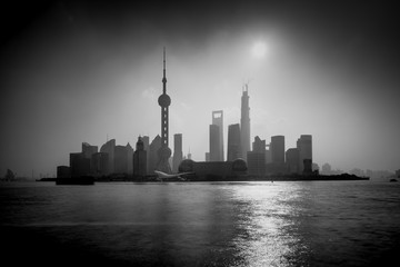 Shanghai sunrise silhouette with Oriental Pearl Tower, Huangpu River, Pudong district, Shanghai, China. Black and White, Long exposure with ND Grad filter, visible noise.