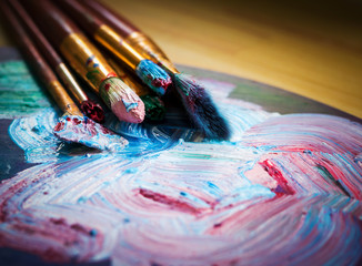 Fototapeta premium artist's workshop. Easel with brushes and tubes of paint