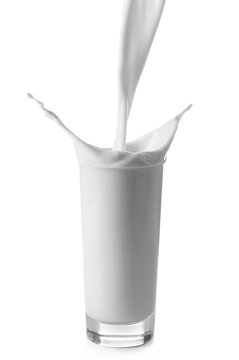 Pouring milk in glass on white background