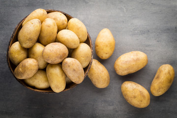 New potato on the bowl, gray background.