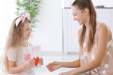 Cute girl and mom with handmade greeting card. Mothers day concept