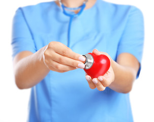 Doctor cardiologist with red heart and stethoscope closeup