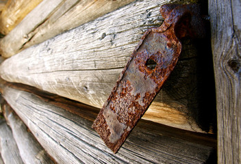 Close-up of old metal hinge on timber wall.