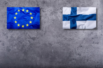 Flags of the Finland and the European Union on concrete background.