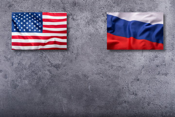 Flags of the USA and russia on concrete background.