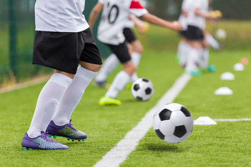 Fototapeta na wymiar Football soccer training for youth teams. Young footballers kicking soccer balls