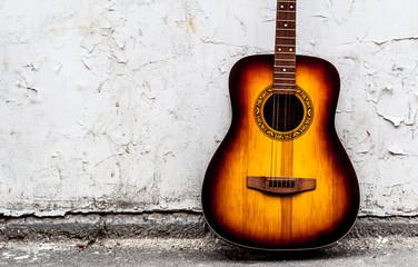 Fototapeta na wymiar classical guitar of wood near a white wall