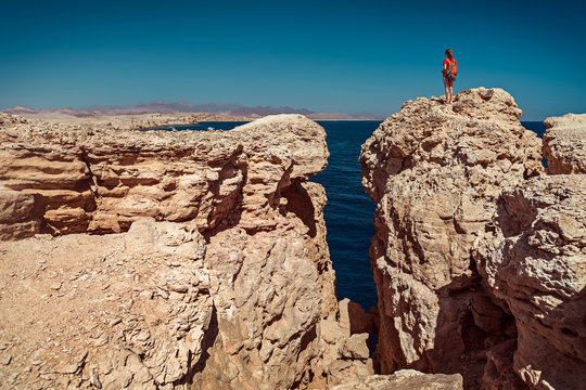 Young lady standing on the top of the cliff in the National Park of Ras Muhammad, Egypt