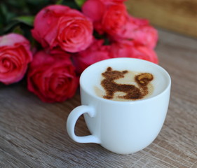 cup of cappuccino and yummy croissant with roses on the table