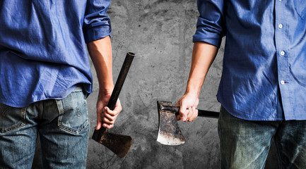 A guy holding old rusty axe, on dark concrete texture background with copy space