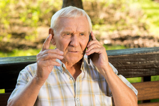 Senior Man With Mobile Phone. Old Guy With Serious Face. Listen To Me, Son. Giving A Wise Advice.