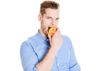 Junger Mann beißt in Apfel