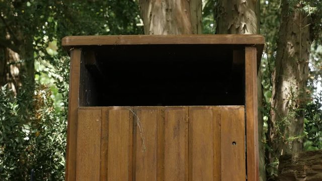 Female dropping trash in the park recycle bin basket 4K 2160p 30fps UltraHD footage - Wooden trash-can used for throwing junk 3840X2160 UHD video