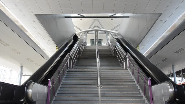 Thai men use escalator for move up at MRT Purple Line skytrain at Bang Yai station in Nonthaburi Province, Thailand