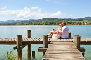 Fototapeta na wymiar A couple on the wooden jetty at the lake. Switzerland
