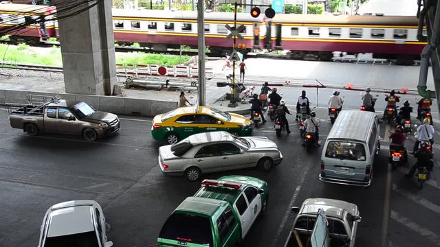 Traffic road and cars stopping wait train running pass cross over road at Rail Level Crossing Barriers at Bang Sue Station on September 14, 2016 in Bangkok, Thailand