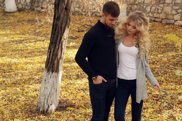 fashion outdoor photo of beautiful tender couple, wearing cozy clothes, walking by autumn park 