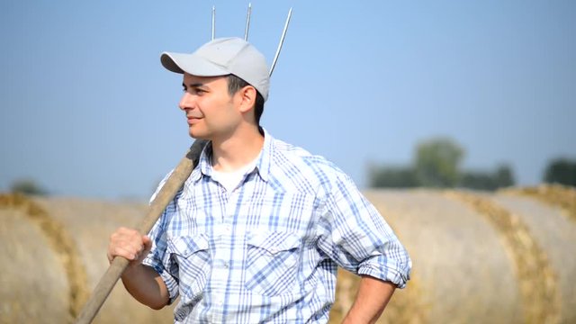 Smiling farmer holding a pitchfork